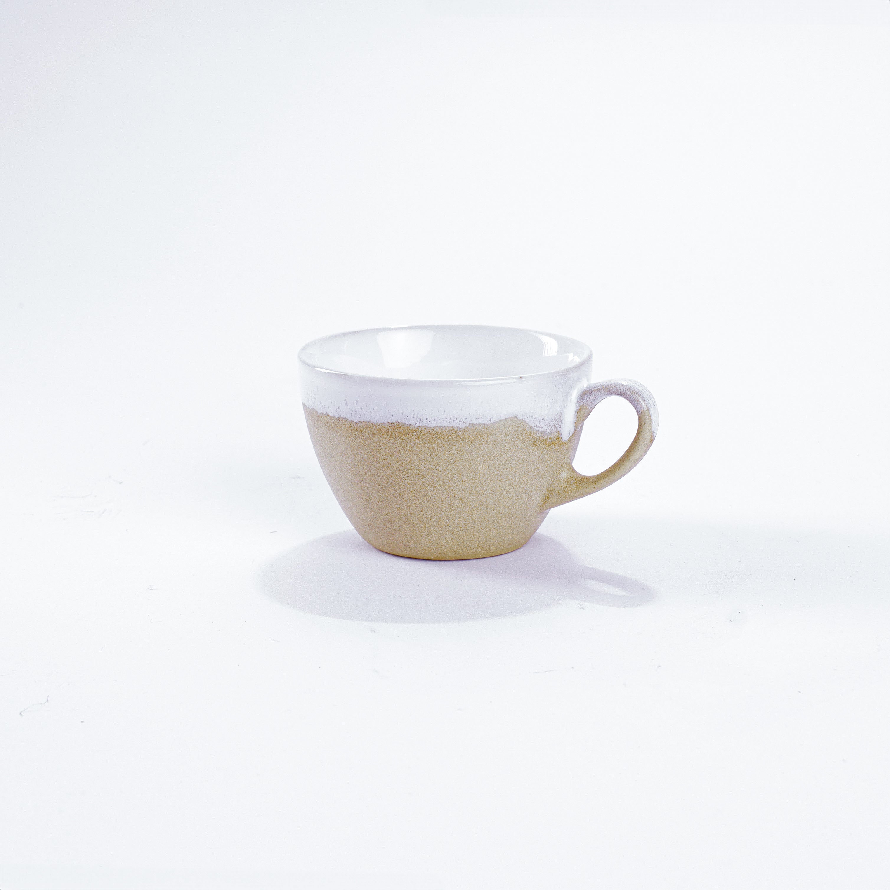 Unsere Keramik Kaffeetasse in der Farbe weiß aus Steinzeug-Keramik mit einer Kapazität von 110 Milliliter, einem Durchmesser von 8 Zentimeter und einer Höhe von 6 Zentimeter. Aus unserer nachhaltigen Töpferei selbst getöpfert und mit handaufgetragener Glasur gebrannt.