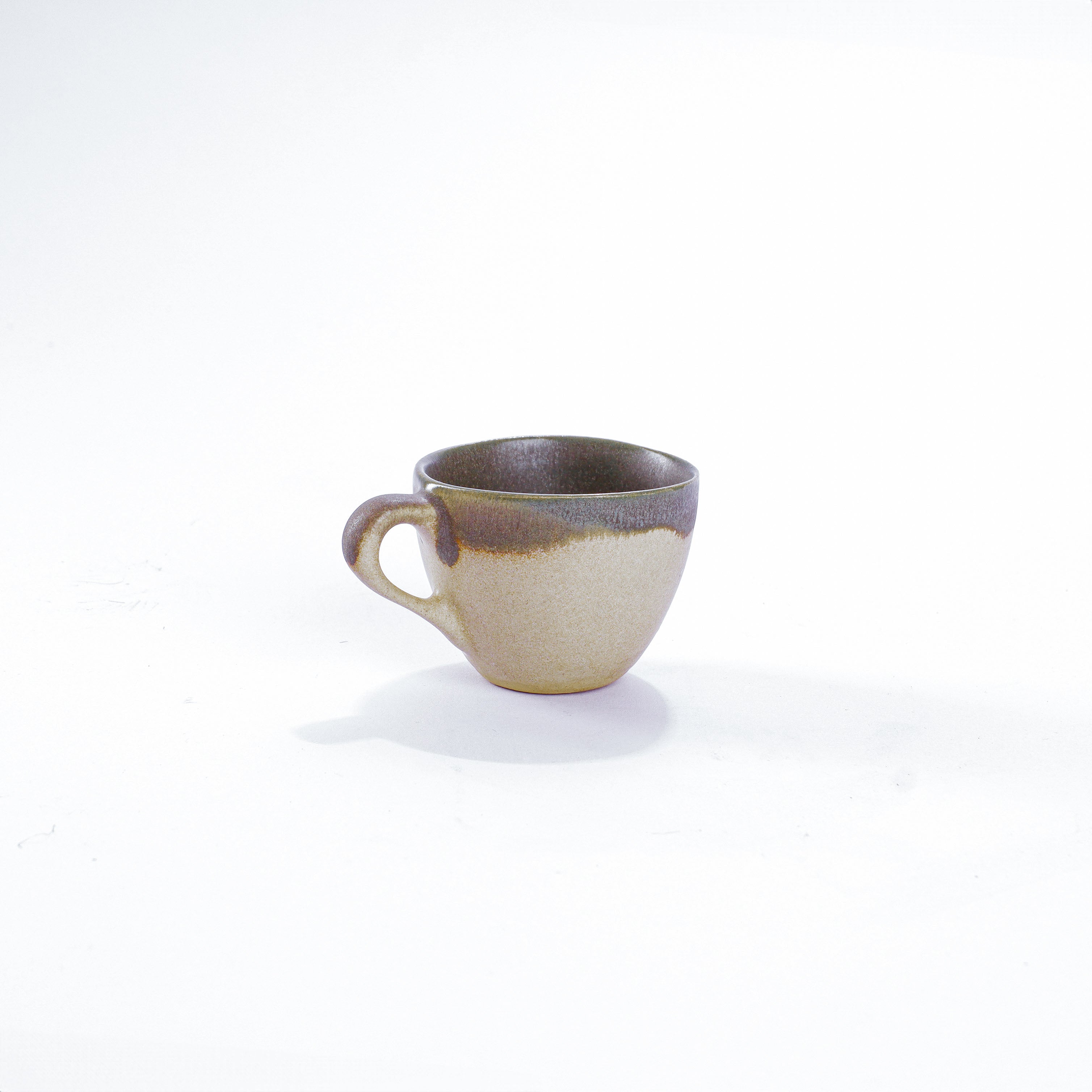 Unsere Keramik Espressotasse in der Farbe Moos aus Steinzeug-Keramik, mit einer Kapazität von 60 Milliliter, einem Durchmesser von 6,5 Zentimeter und einer Höhe von 5 Zentimeter. Aus unserer nachhaltigen Töpferei selbst getöpfert und mit handaufgetragener Glasur gebrannt.