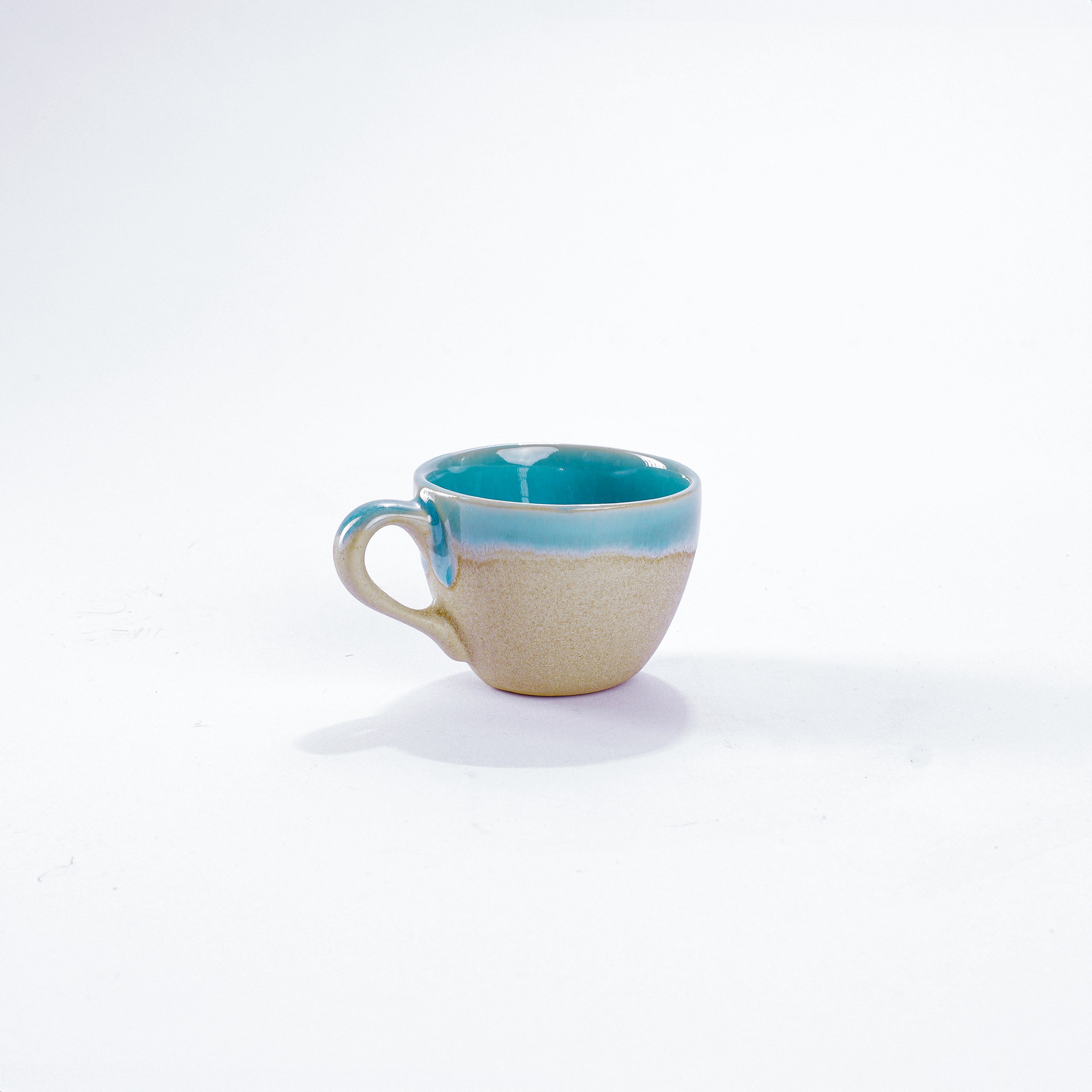 Unsere Keramik Espressotasse in der Farbe türkis aus Steinzeug-Keramik, mit einer Kapazität von 60 Milliliter, einem Durchmesser von 6,5 Zentimeter und einer Höhe von 5 Zentimeter. Aus unserer nachhaltigen Töpferei selbst getöpfert und mit handaufgetragener Glasur gebrannt.