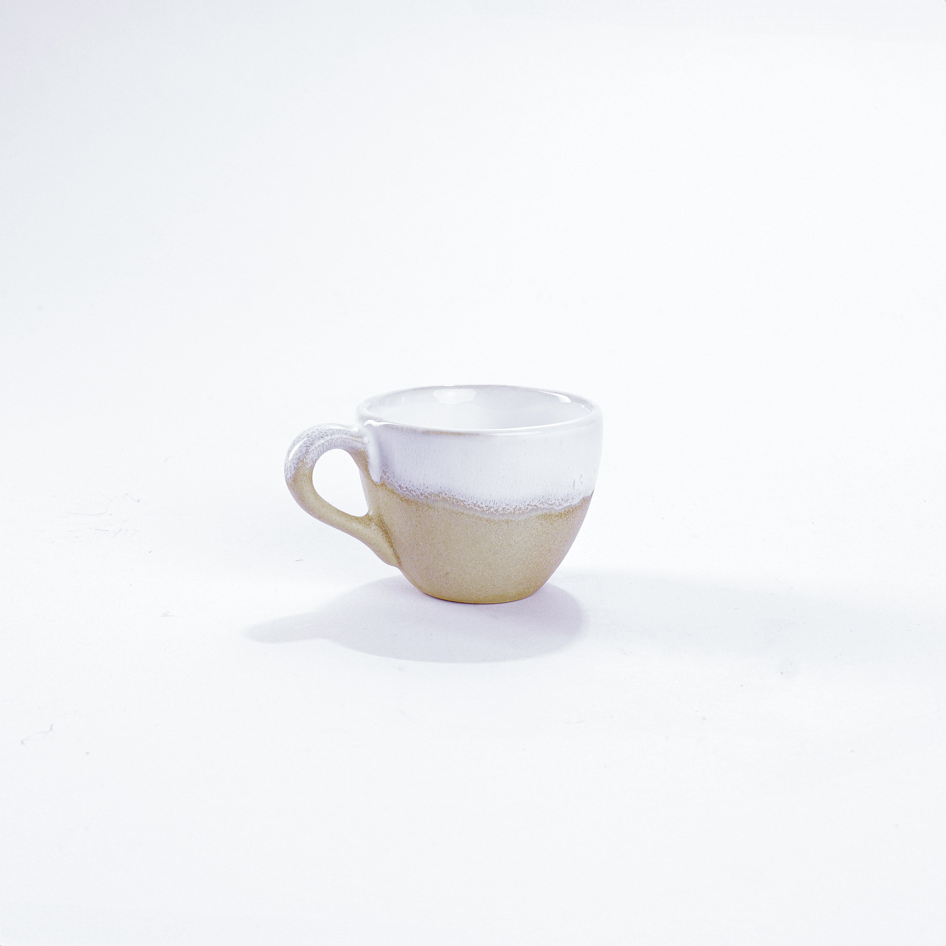 Unsere Keramik Espressotasse in der Farbe Weiß aus Steinzeug-Keramik, mit einer Kapazität von 60 Milliliter, einem Durchmesser von 6,5 Zentimeter und einer Höhe von 5 Zentimeter. Aus unserer nachhaltigen Töpferei selbst getöpfert und mit handaufgetragener Glasur gebrannt.