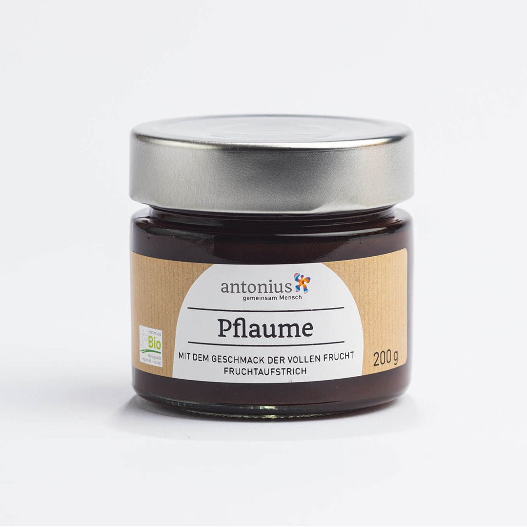 Ein mit einem Metalldeckel verschlossenes Glas mit Pflaumen-Fruchtaufstrich und der Aufschrift "Mit dem Geschmack der vollen Frucht".