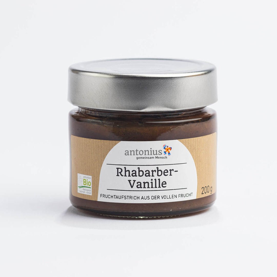 Ein mit einem Metalldeckel verschlossenes Glas mit Schwarze Johannisbeere-Fruchtaufstrich und der Aufschrift "Fruchtaufstrich aus der vollen Frucht".