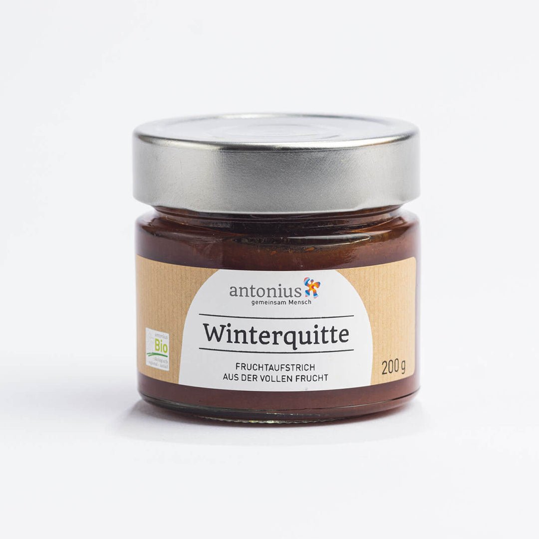 Ein mit einem Metalldeckel verschlossenes Glas mit Winterquitten-Fruchtaufstrich und der Aufschrift "Aus der vollen Frucht".