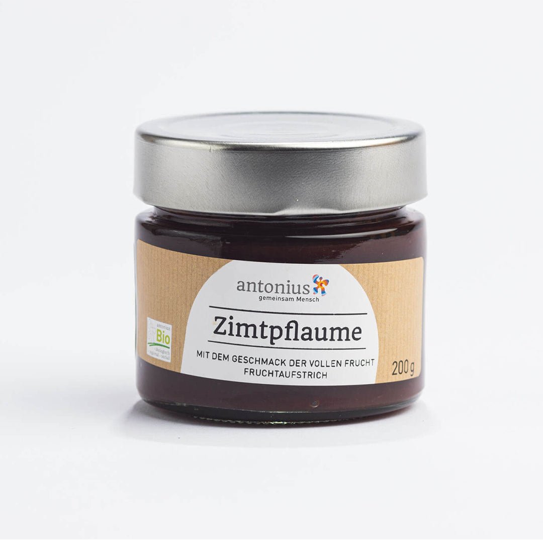 Ein mit einem Metalldeckel verschlossenes Glas mit Zimtpflaume-Fruchtaufstrich und der Aufschrift "Mit dem Geschmack der vollen Frucht".