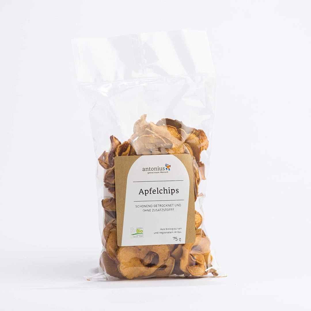 75g Chips aus getrockneten Apfel-Scheiben aus biologischem und regionalem Anbau in einem durchsichtigen Beutel. Auf dem Etikett steht: "Apfelchips - schonend getrocknet und ohne Zusatzstoffe".