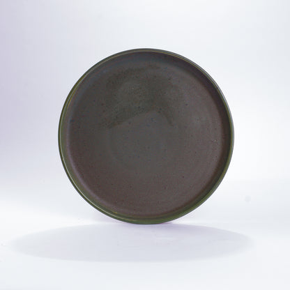 Unserer runder Keramikteller in der mittleren Größe mit einem Durchmesser von 26,5 Zentimeter. In der Farbe Moos und aus Steinzeug-Keramik. Aus unserer nachhaltigen Töpferei selbst getöpfert und mit handaufgetragener Glasur gebrannt.