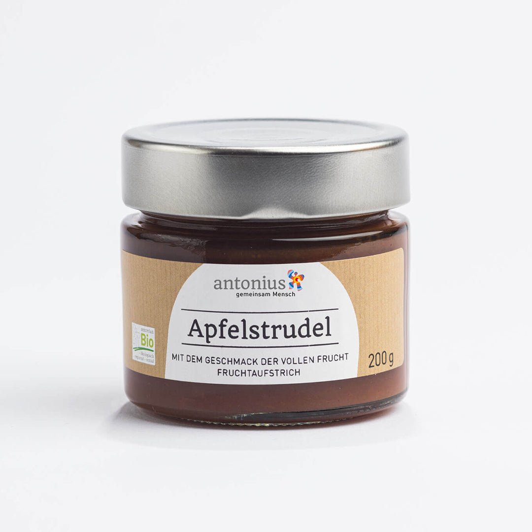 Ein mit einem Metalldeckel verschlossenes Glas mit Apfelstrudel-Fruchtaufstrich und der Aufschrift &quot;Mit dem Geschmack der vollen Frucht&quot;.