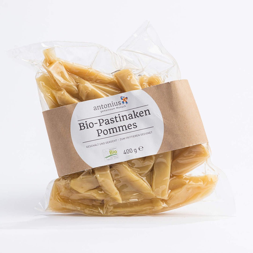 400g geschälte und vorgekochte Pastinaken-Pommes aus regionalem und biologischem Anbau in einem durchsichtigen, vakuumierten Beutel.  Auf dem Etikett steht: &quot;Bio-Pastinaken-Pommes: geschält und gekocht - zum Frittieren geeignet.